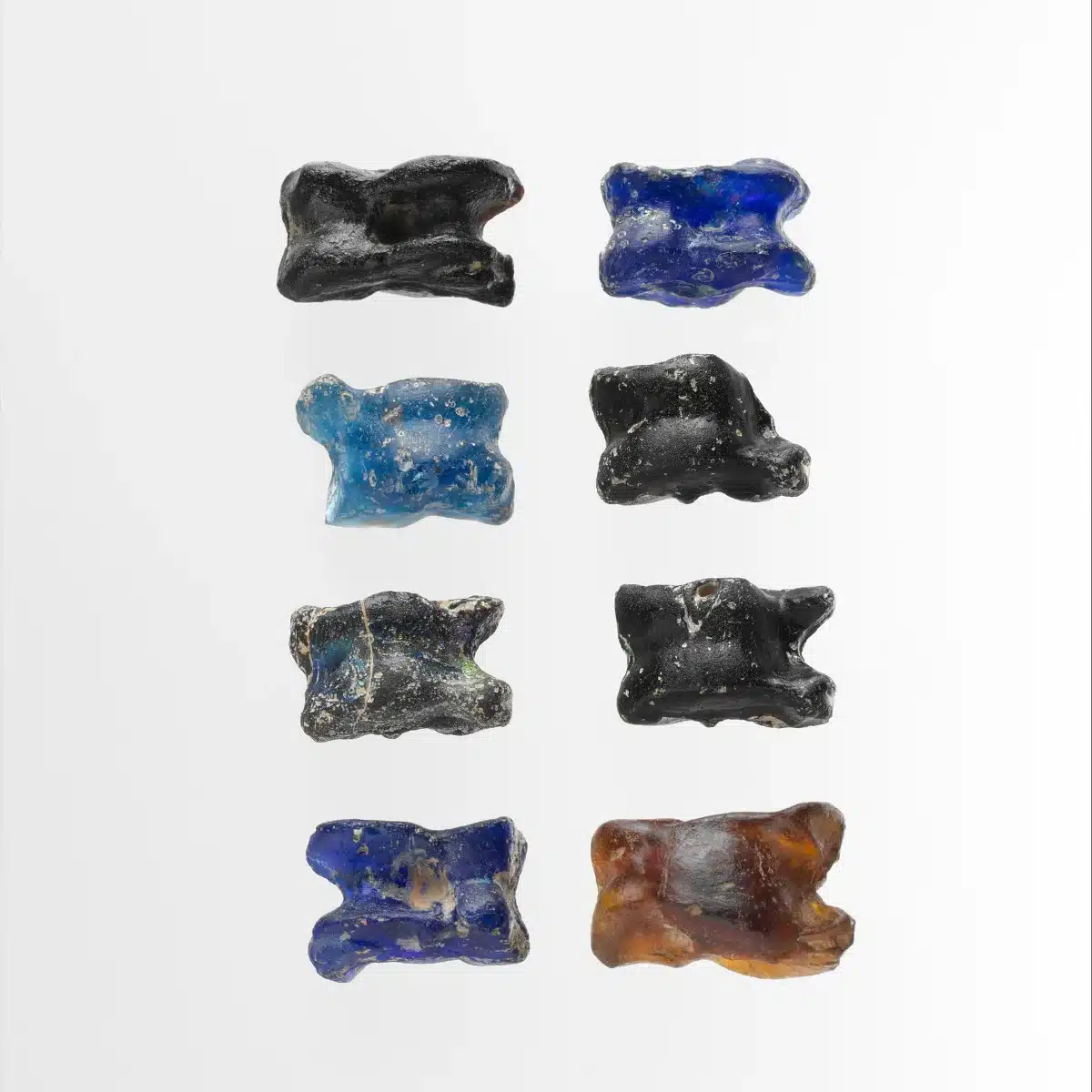 Huit osselets antiques en verre bleu et noir, objets utilisés pour l’astragalomancie, la divination par les osselets dans l’Antiquité