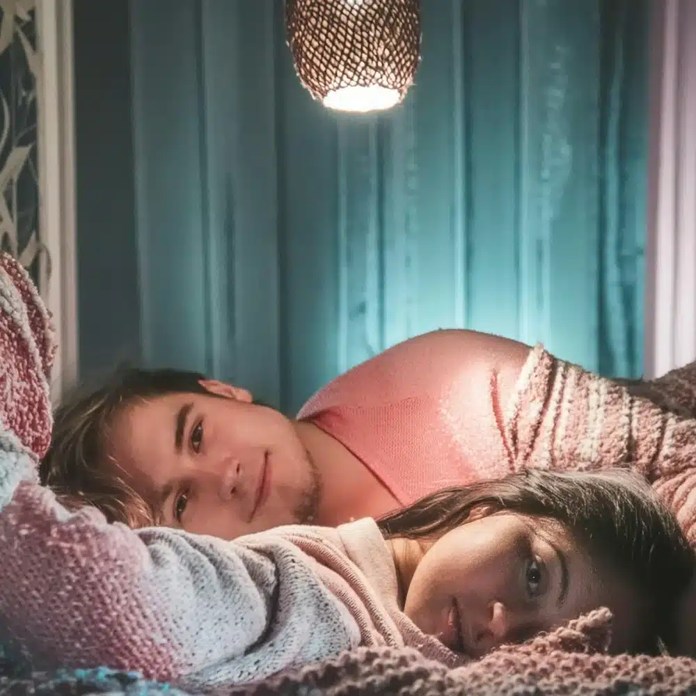 Jeune couple allongé sur un lit : la récession sexuelle, 28 % des 18-24 ans sans rapport dans l’année