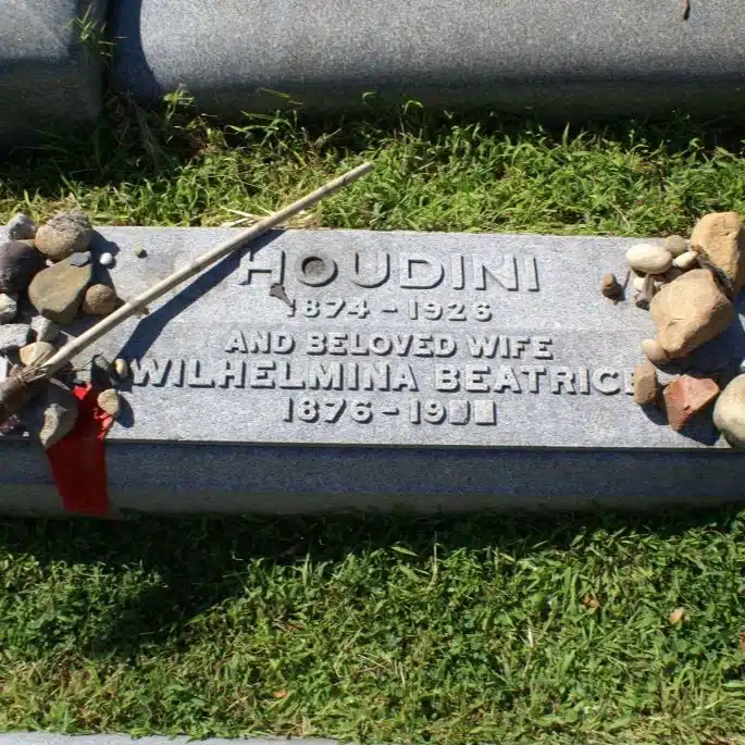 Plaque de la tombe de Harry Houdini, 1874-1926, au cimetière Machpelah dans le Queens à New York, avec des cailloux déposés par les visiteurs et une baguette de magicien